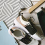 pair of white-and-black low-top sneakers near black skirt on brown clothes hanger top view photography